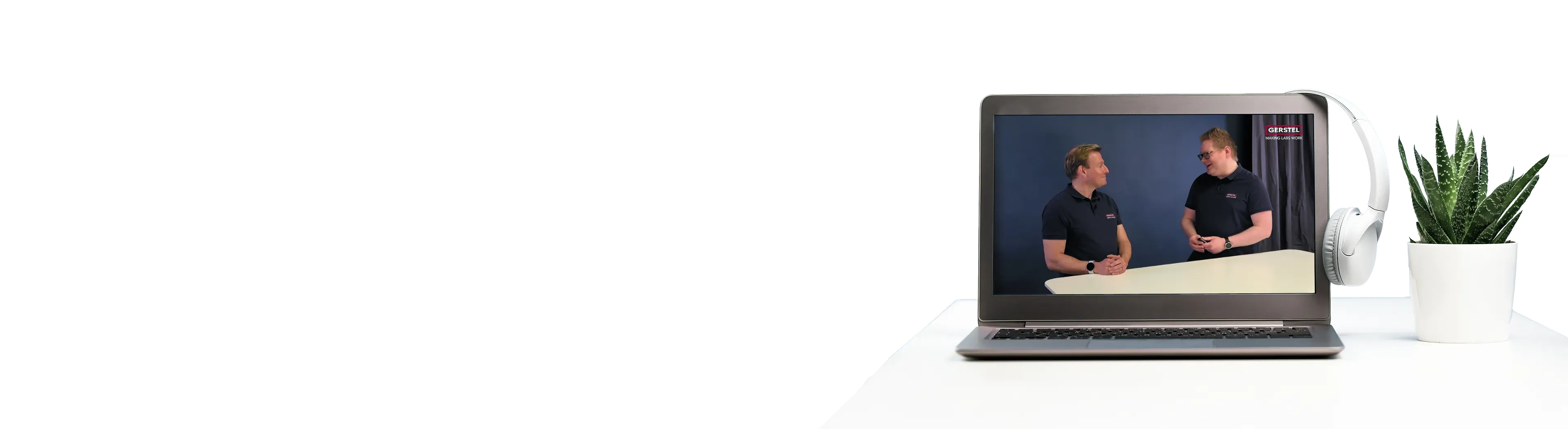 Schreibtisch mit Laptop und Kopfhörern sowie einem Ausschnitt aus einem GERSTEL Webinar